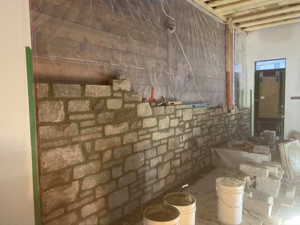 Un mur de briques est en cours de construction dans une pièce.