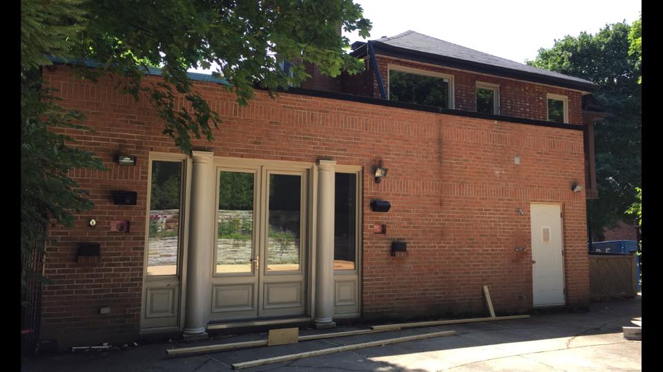 Un grand bâtiment en brique avec une porte et des fenêtres blanches.