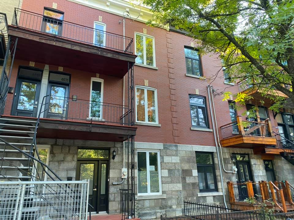 Un grand bâtiment en brique avec des escaliers menant au deuxième étage.