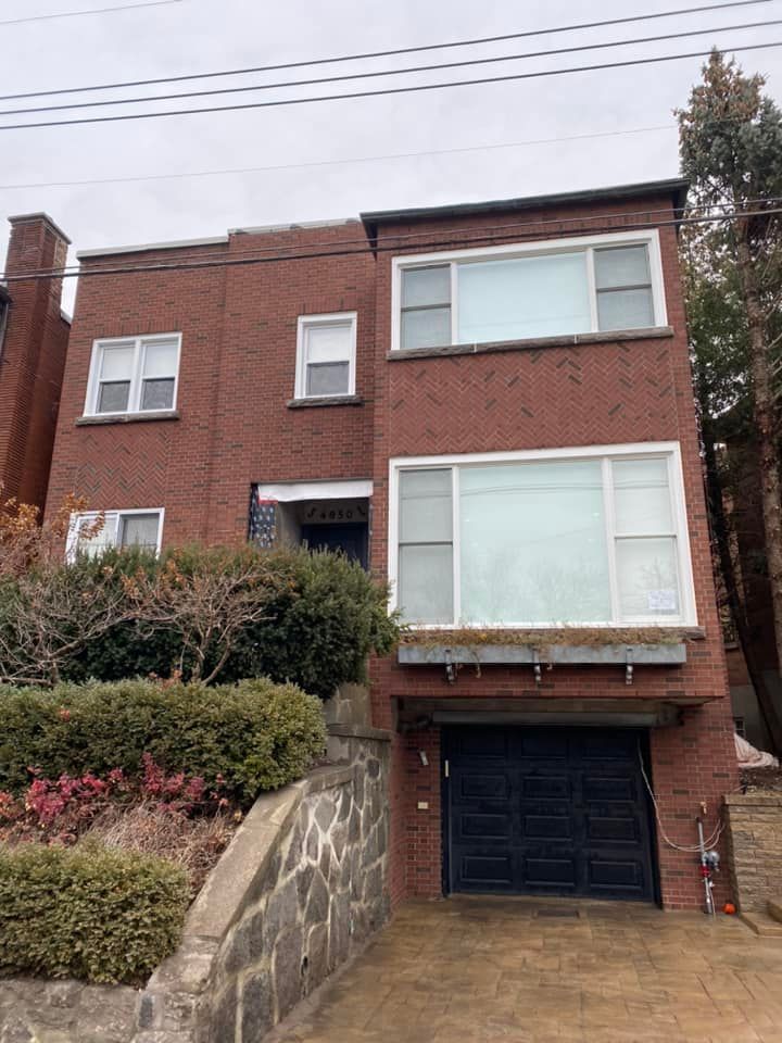 Une grande maison en brique rouge avec une porte de garage noire