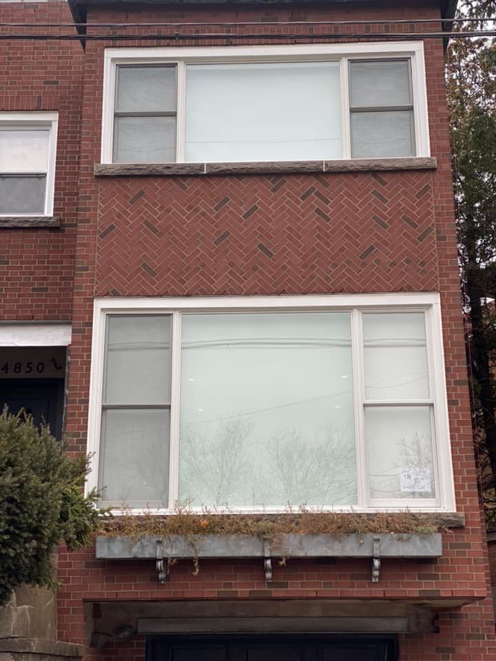 Un immeuble en brique avec beaucoup de fenêtres et un balcon.