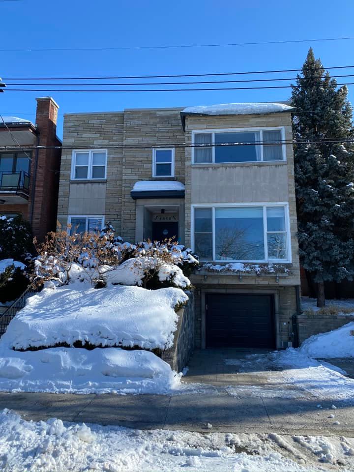 Une grande maison avec un garage est couverte de neige