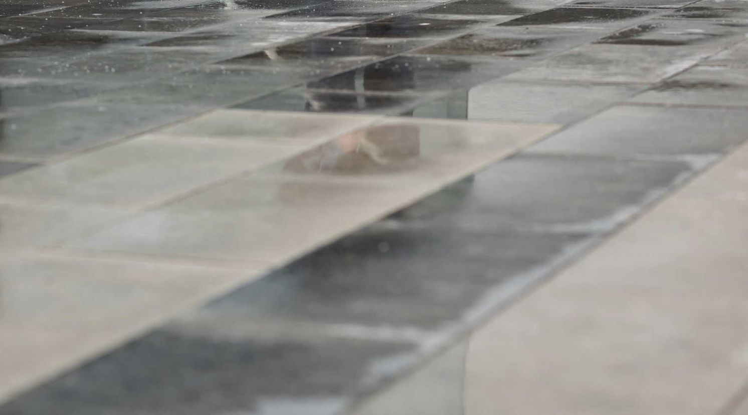 A close up of a tiled floor in the rain.