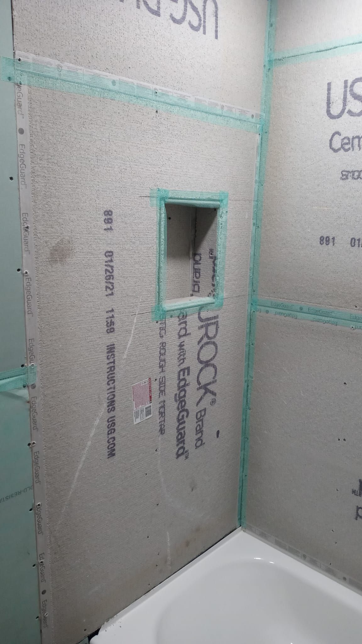 A kitchen with white cabinets , stainless steel appliances , and a large island.