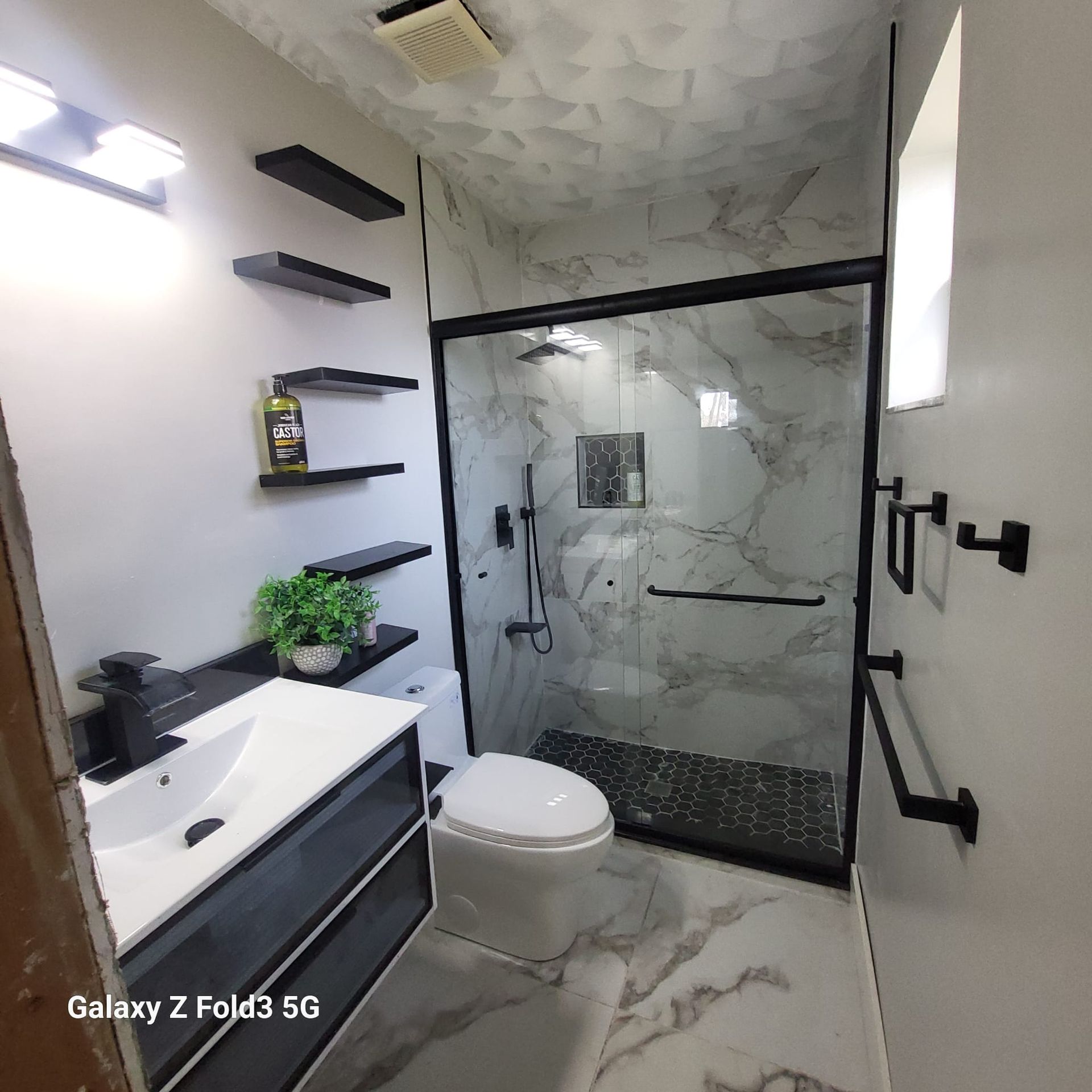 A bathroom with a toilet , sink , and shower.