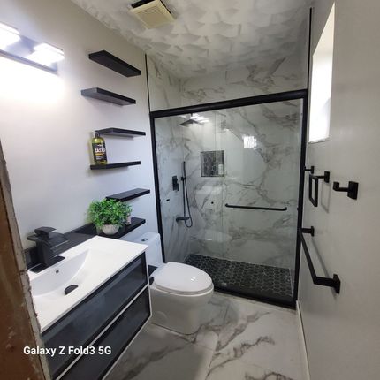 A bathroom with a bathtub , toilet , sink and walk in shower.