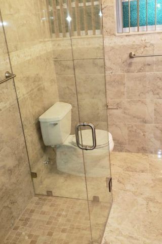 A bathroom with a toilet and a glass shower door.