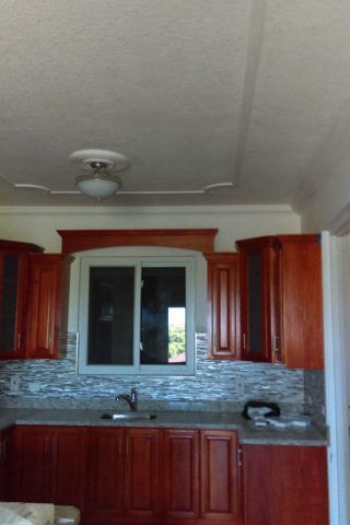 A kitchen with wooden cabinets and a window