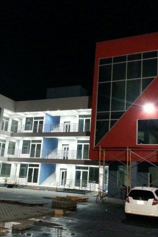A white car is parked in front of a building at night