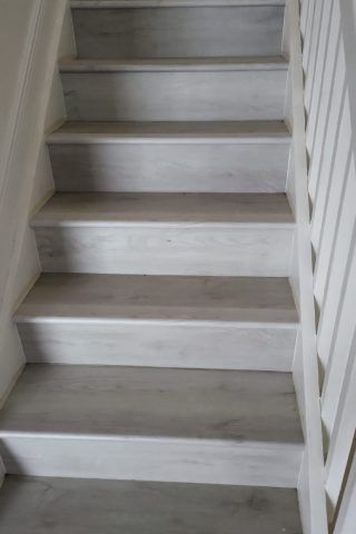 A set of white wooden stairs with a white railing.