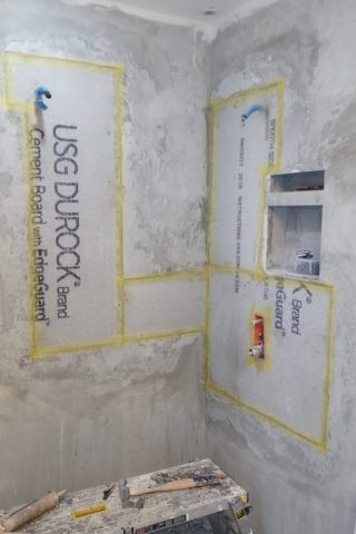 A bathroom under construction with a sign on the wall.