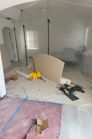 A room is being painted and covered in plastic.