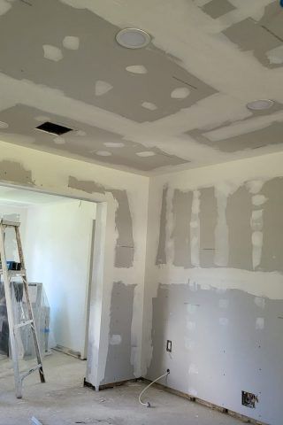 A room with a ladder and a ceiling that is being remodeled.