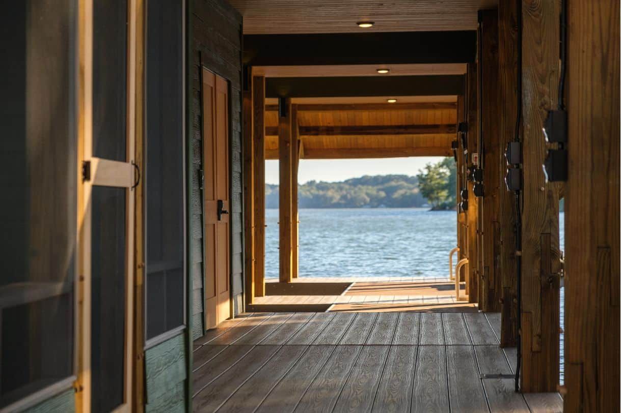 A long hallway leading to a lake with a view of the water.