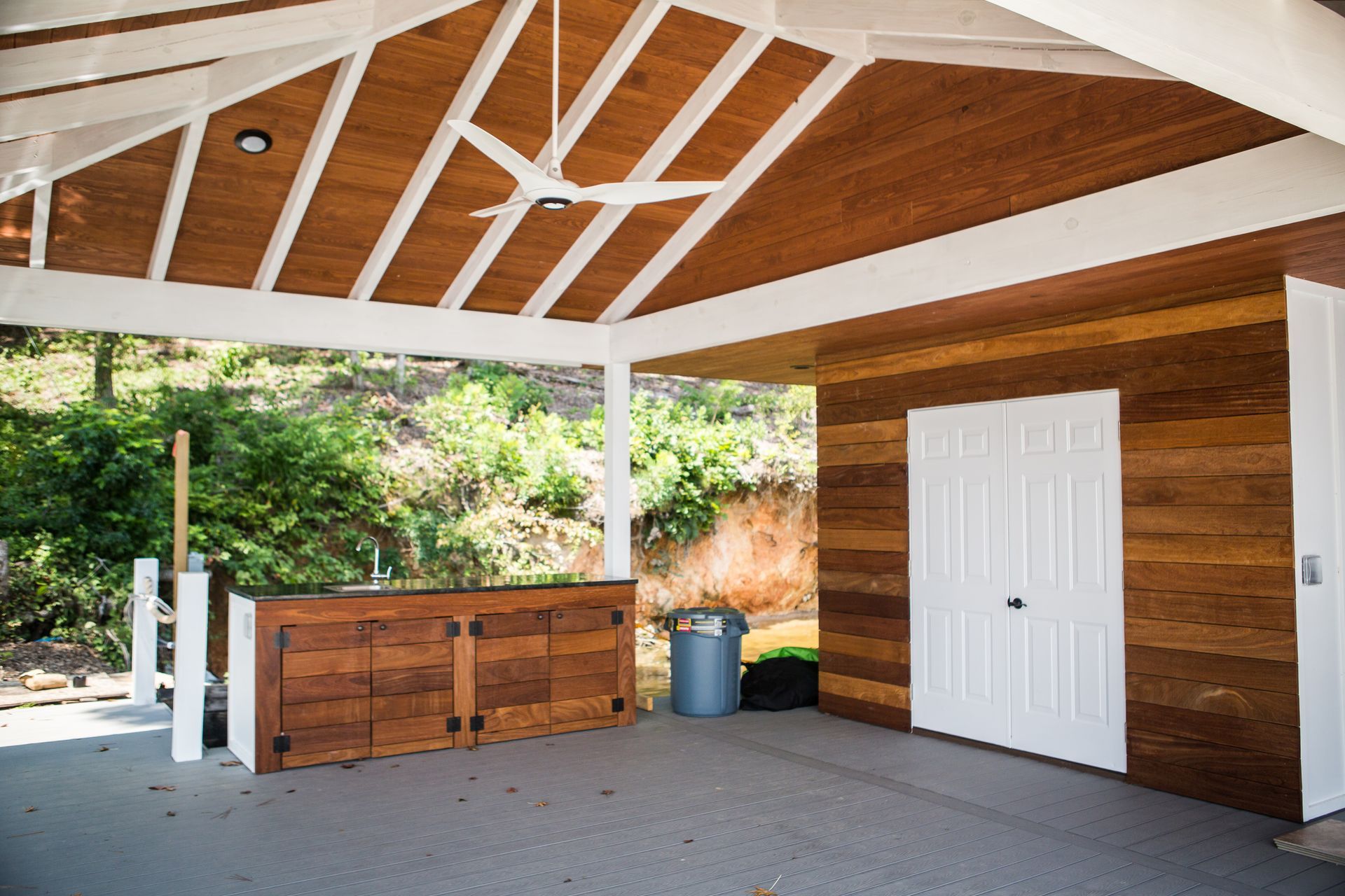 A wooden building with a ceiling fan hanging from it