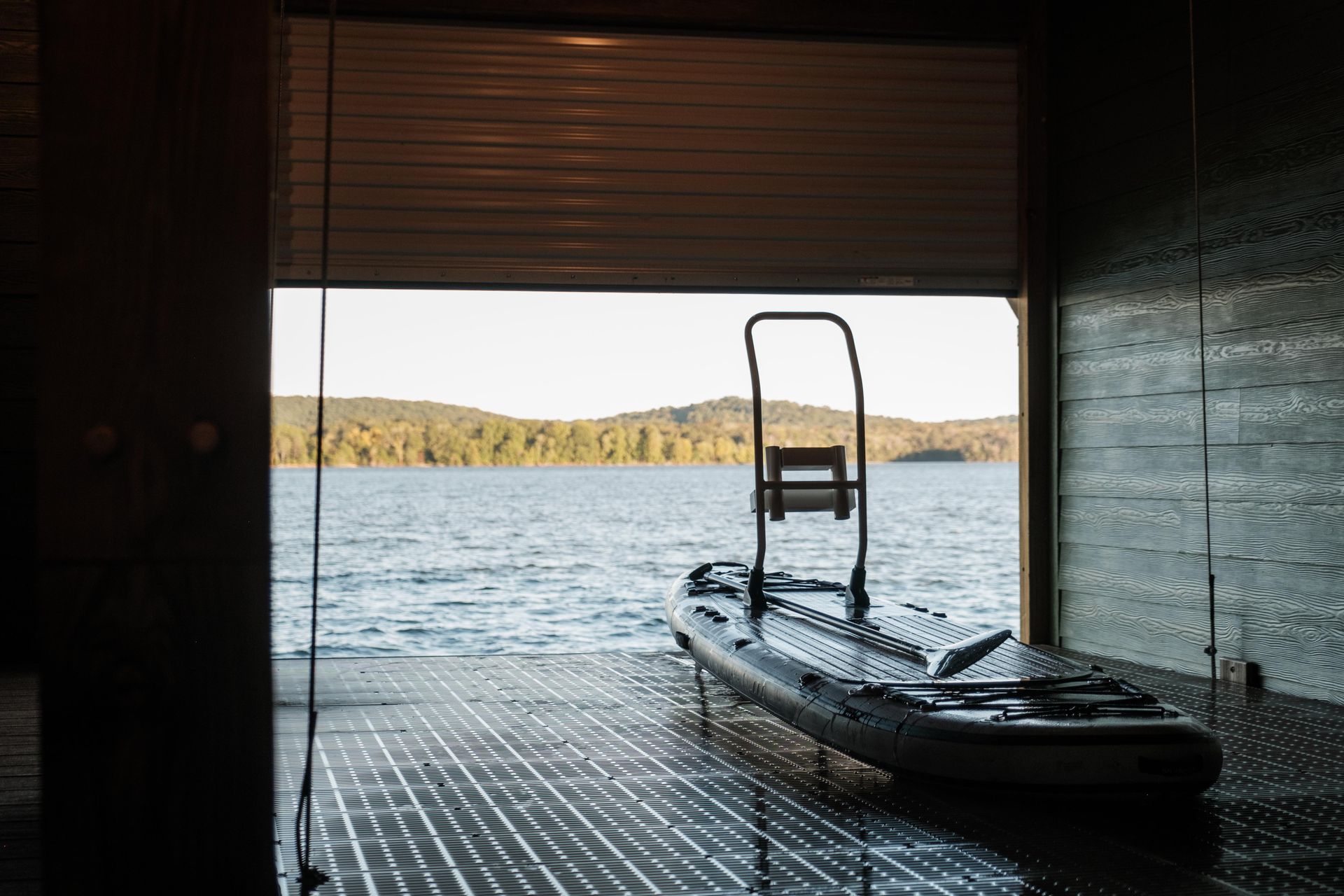 A kayak is parked in a garage next to a lake.