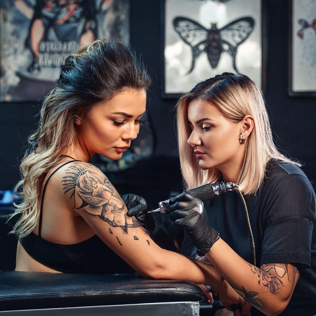 Woman getting tattooed and wincing just a little