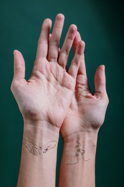 Delicate minimalist tattoo with fine linework and simple geometric shapes on the wrist