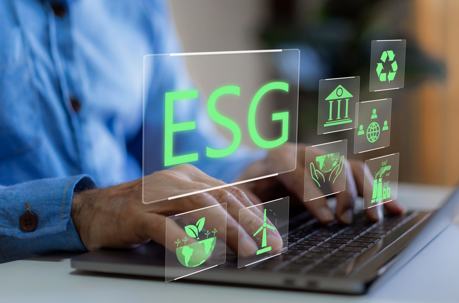 A person is typing on a laptop computer with a screen that says esg.