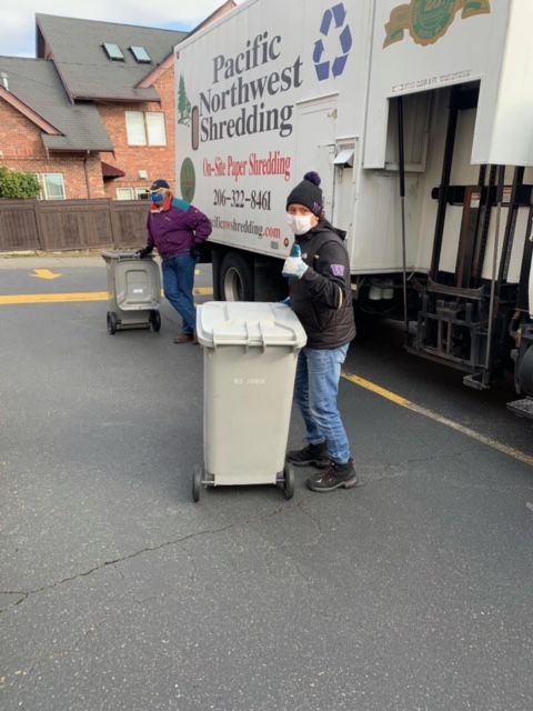 A pacific northwest shredding truck is parked in a parking lot