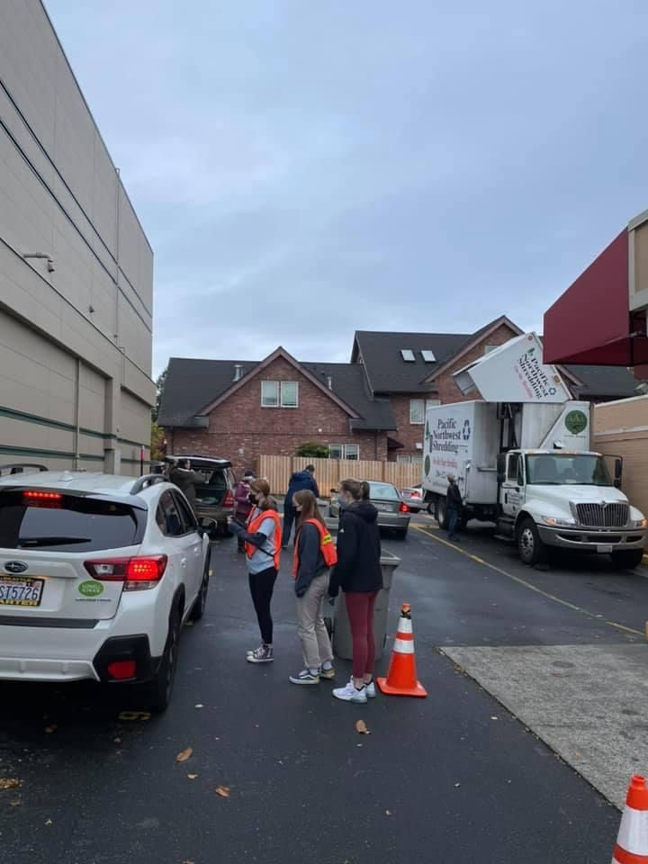 A group of people are standing in a parking lot next to a truck.