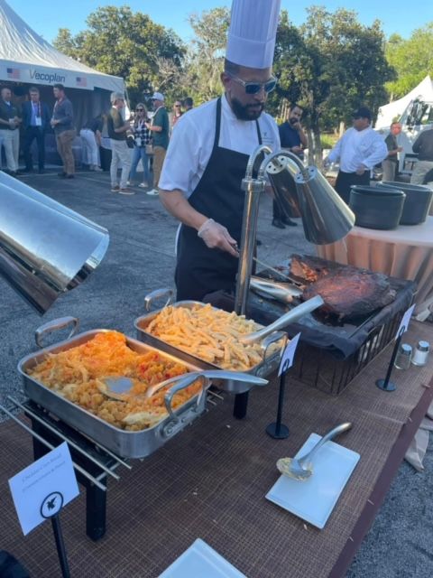 A chef is preparing food at a buffet table