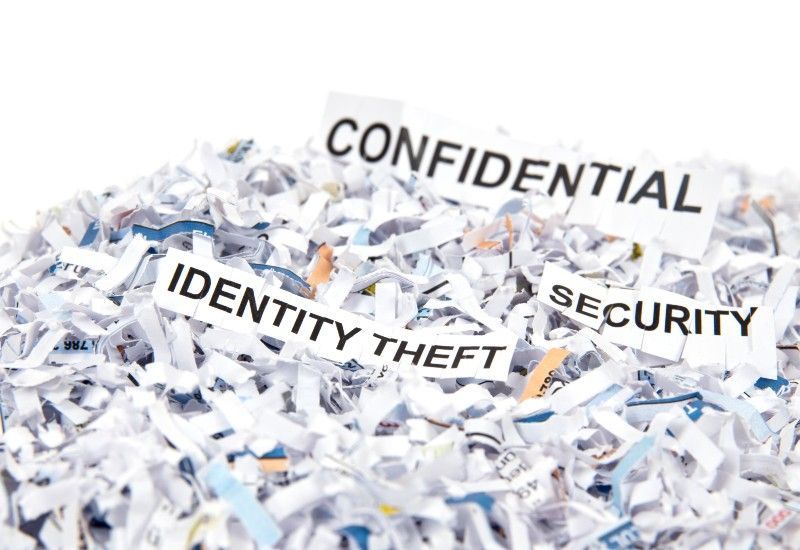 A pile of shredded paper with the words confidential identity theft and security written on them.