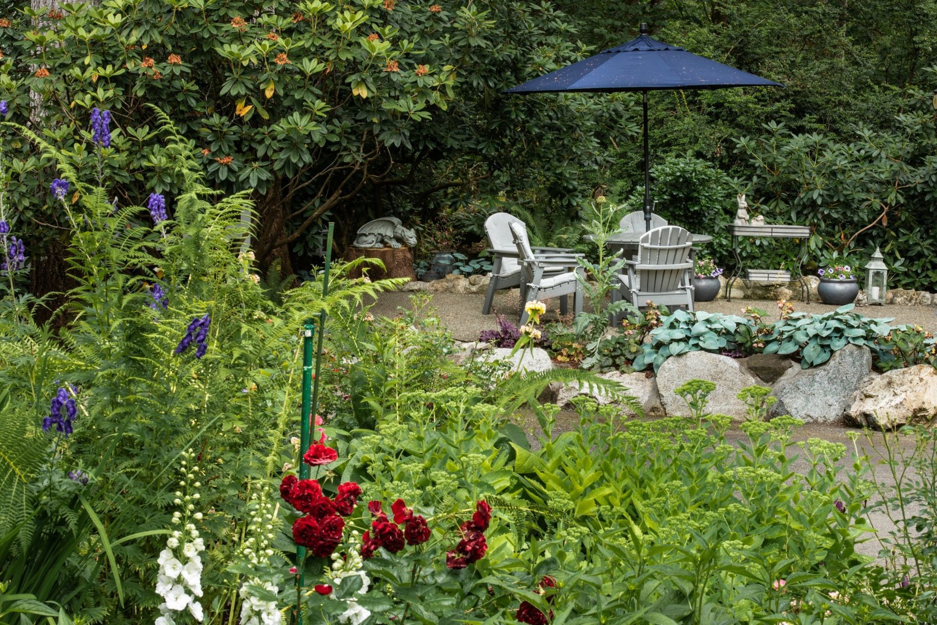 There is a blue umbrella in the middle of the garden.