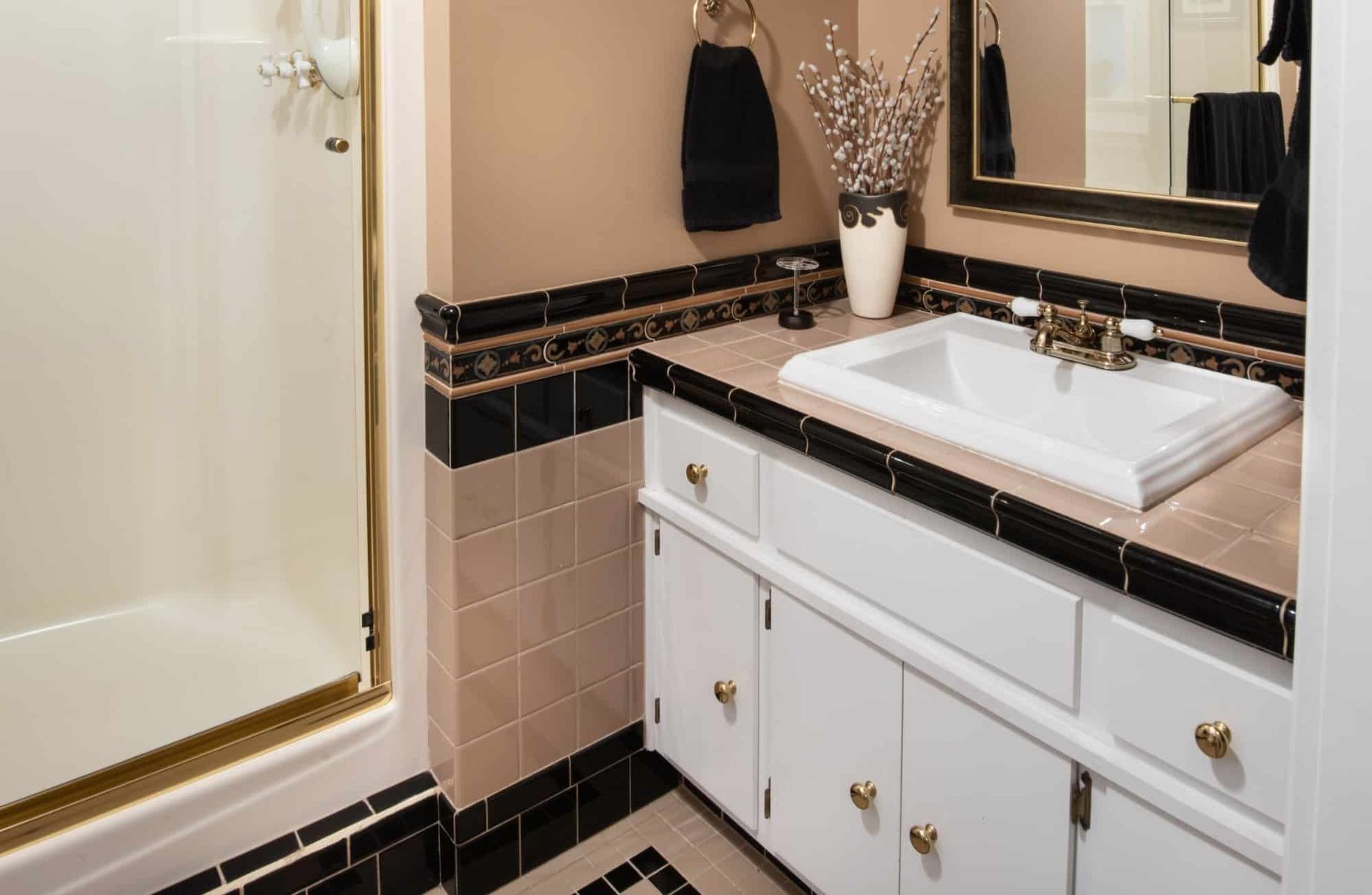 A bathroom with a sink , mirror and shower
