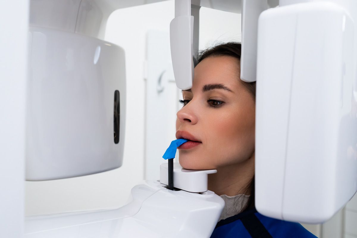 A woman is getting an x-ray of her teeth in a dental office.