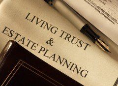 A pen is sitting on top of a living trust and estate planning book.