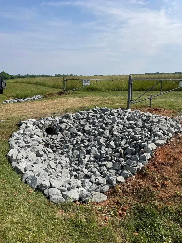 A pile of rocks is sitting in the middle of a grassy field.