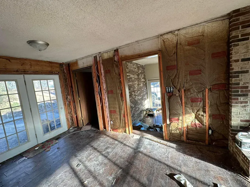 An empty room with a brick wall and a wooden floor.