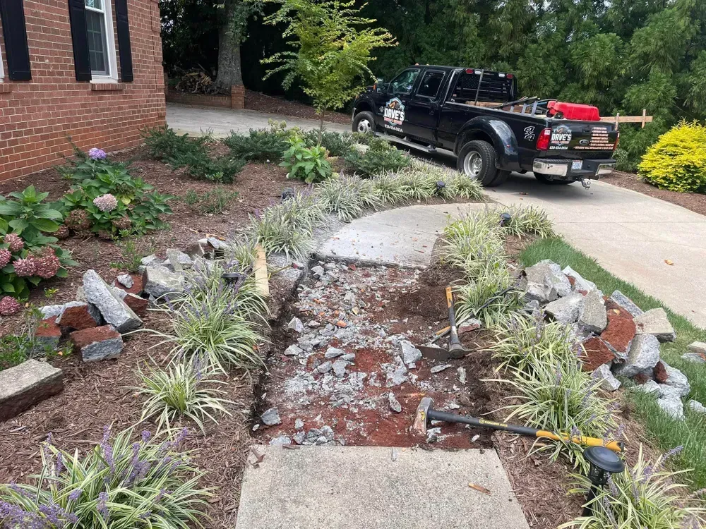 A black truck is parked in front of a brick house.