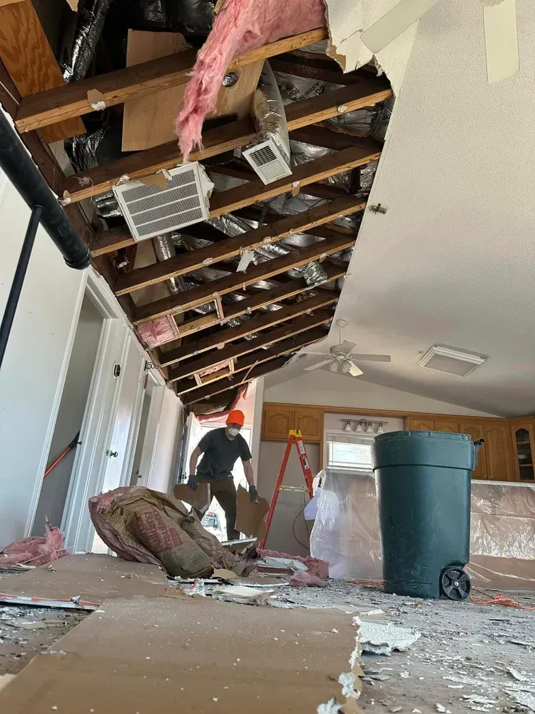 A man is working on the ceiling of a house.