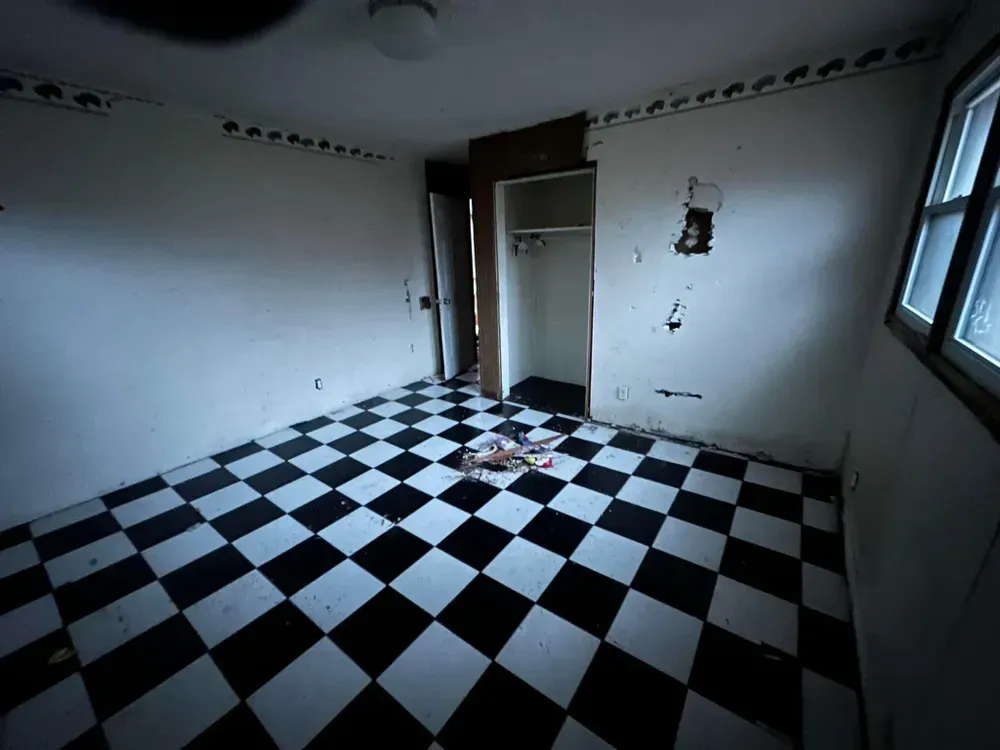 An empty room with a black and white checkered floor
