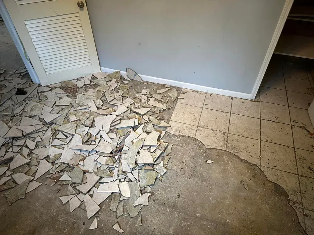 A room with a lot of broken tiles on the floor.