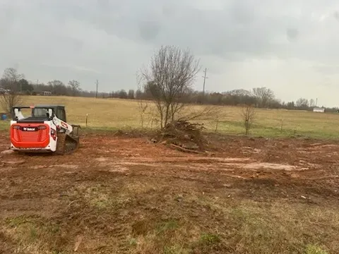 A bulldozer is sitting in the middle of a dirt field.