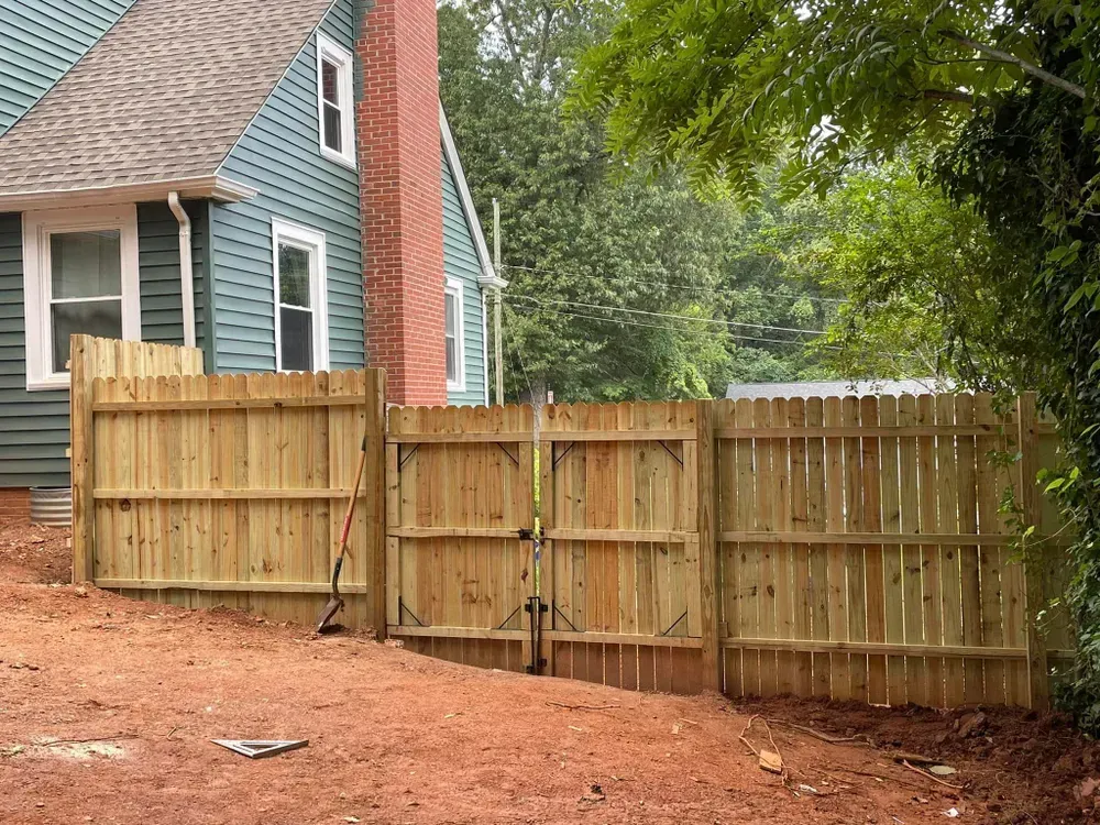 A wooden fence is being built in front of a house