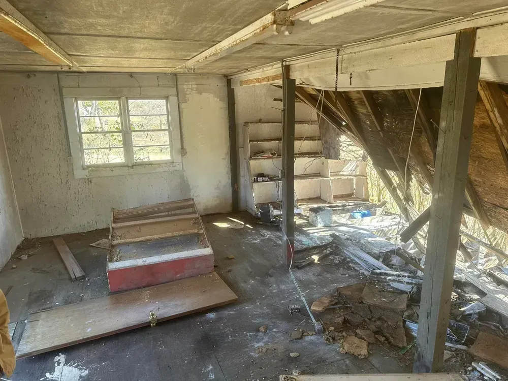 An empty room with a staircase and a window.