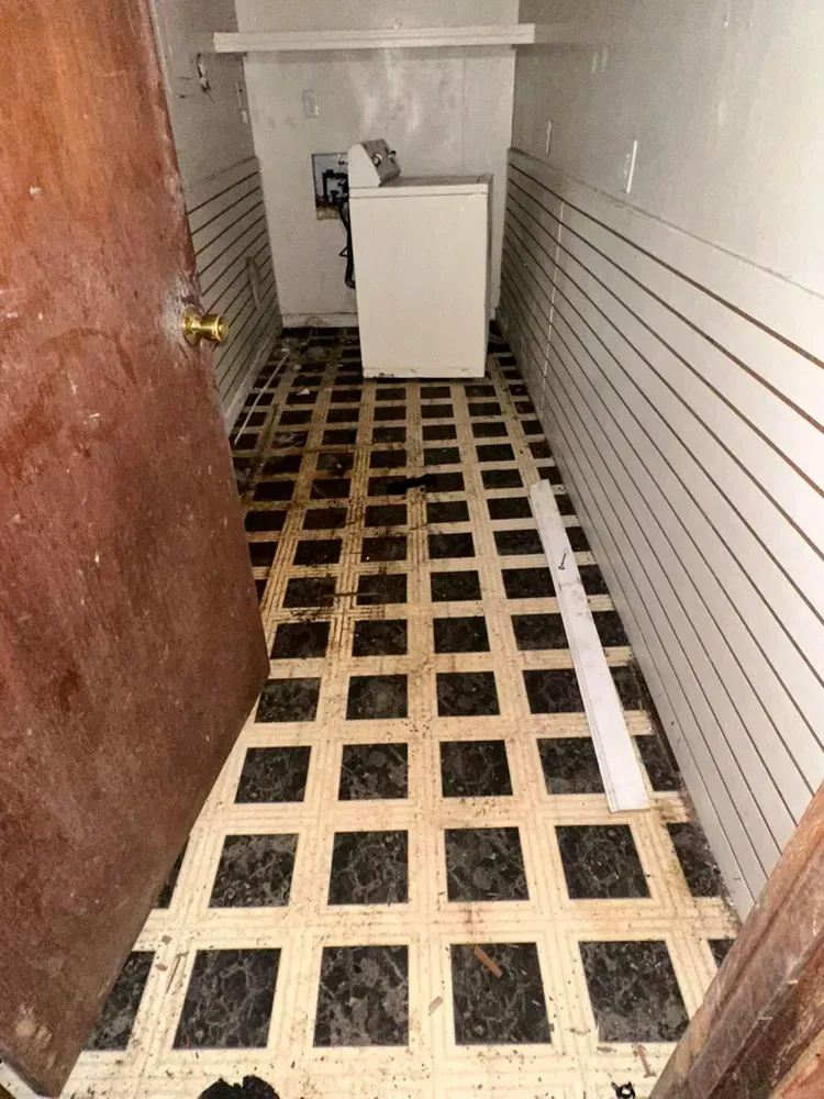 A laundry room with a washer and dryer and a wooden floor.