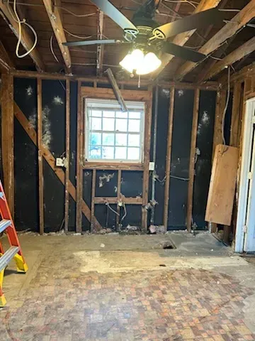 A room with a ceiling fan and a window in it.