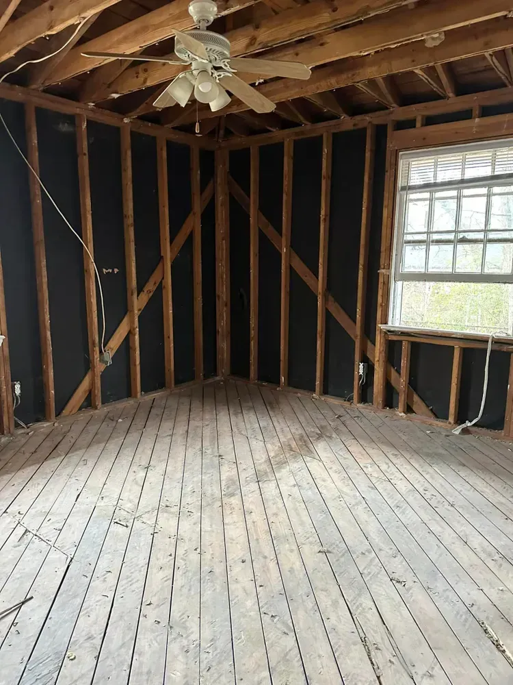 An empty room with a ceiling fan and a window