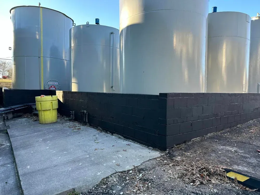 A row of large tanks are sitting next to each other in a parking lot.