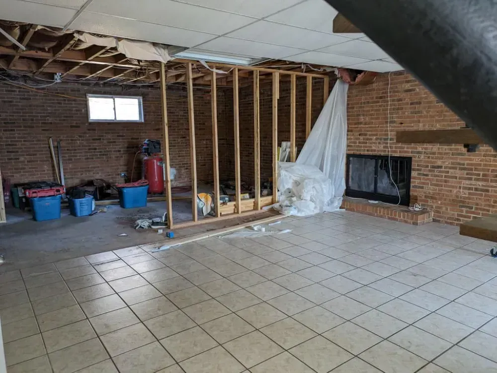 An empty room with a brick wall and a fireplace.