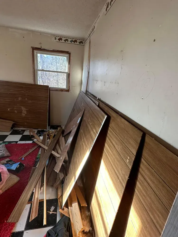A room with a lot of wooden boards on the floor and a window.