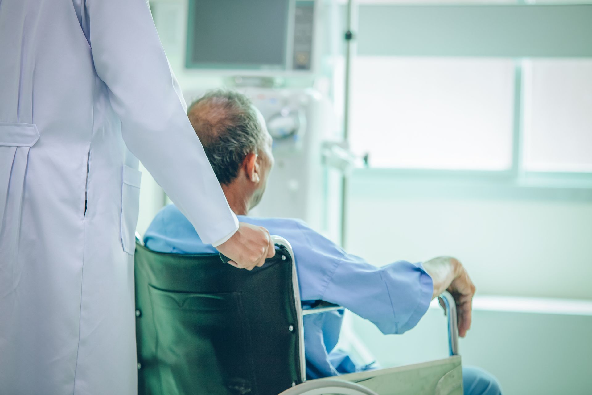 Person in A Wheelchair Is Pushed by A Healthcare Worker — Highland, UT — Renal Associates of Montgomery PC Person in A Wheelchair Is Pushed by A Healthcare Worker — Highland, UT — Renal Associates of Montgomery PC