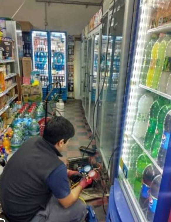 Técnico utilizando herramientas para ajustar un motor industrial plateado dentro de un armario.