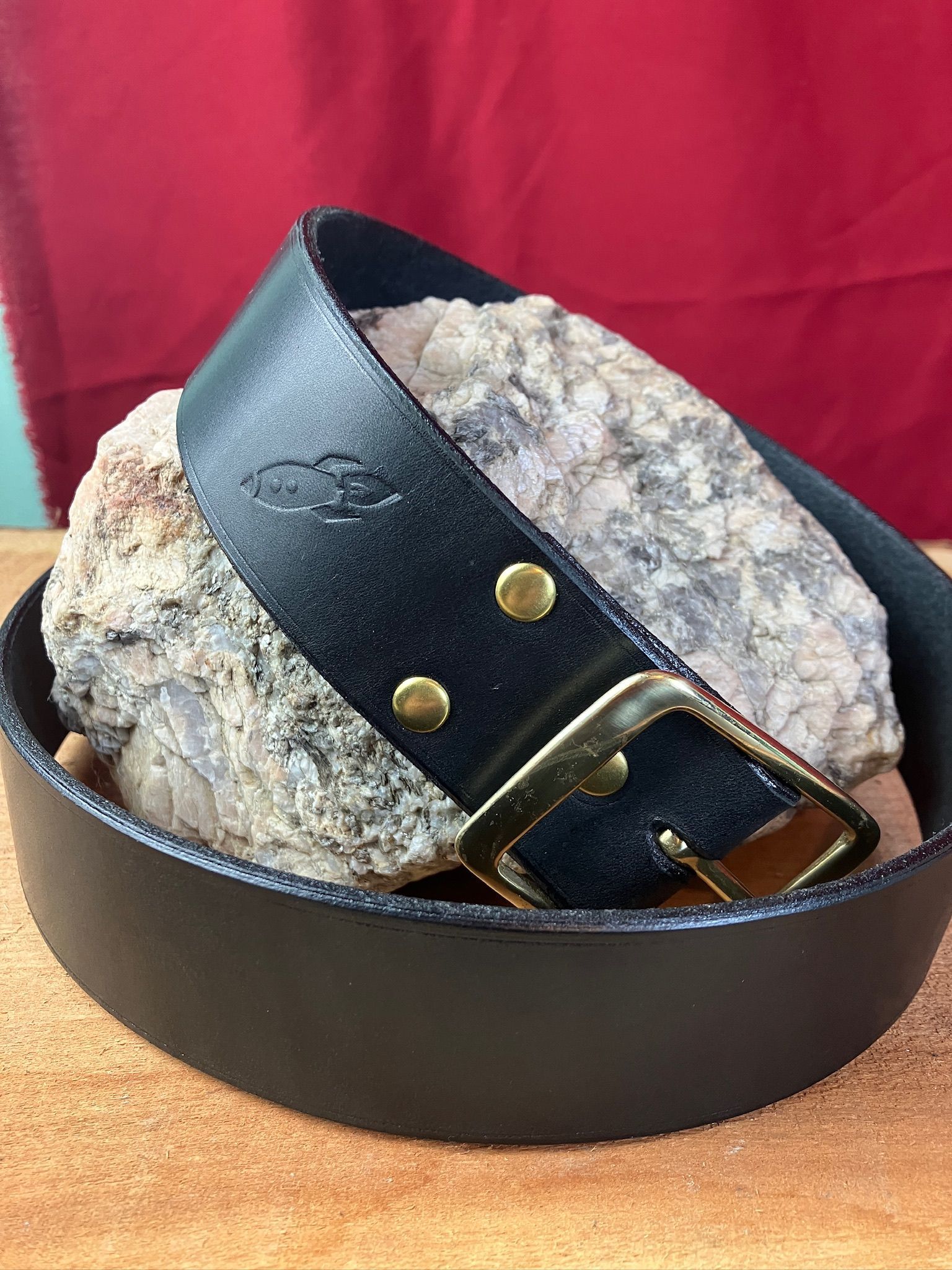 A black full grain leather handcrafted belt with brass hardware