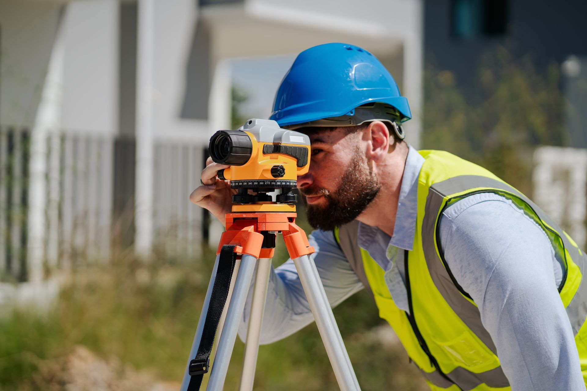 An engineer uses a survey camera to measure levels accurately at a construction site.